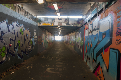 825712 Gezicht in de fietstunnel onder het Westplein te Utrecht, uit het zuiden, met op de wanden graffiti.N.B. De ...
